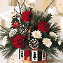 christmas arrangement of white and red flowers and Christmas greens in a  charming country basket.
