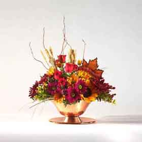 thanksgiving arrangement with autumn flowers in copper bowl